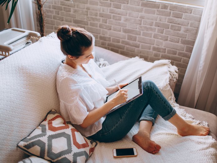 kvinne på sofaen som surfer på en iPad