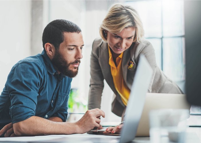 femme et homme travaillant devant l’ordinateur